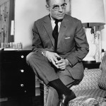 Ancel Keys perched on a sofa, pipe in hand, in his home