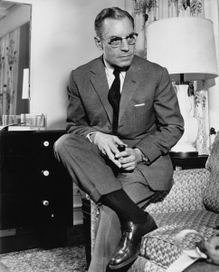 Ancel Keys perched on a sofa, pipe in hand, in his home
