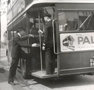 Private: Passenger boarding double-decker bus in London, England